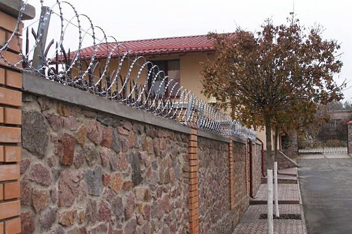 Плоский барьер безопасности на заборе из камня