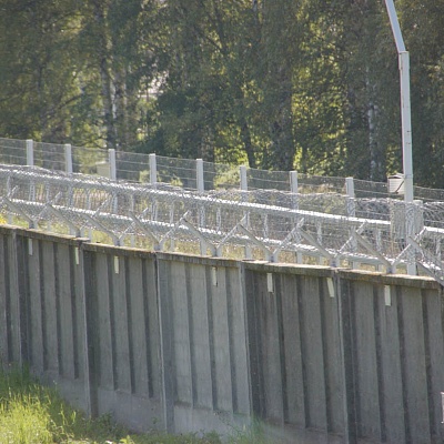 Спиральный барьер безопасности СББ АКЛ на бетонном заборе